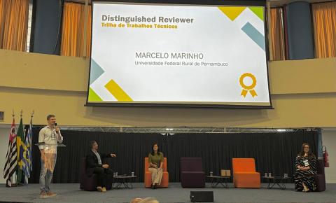 Telão com a indicação de destaque para o prof. Marcelo Marinho